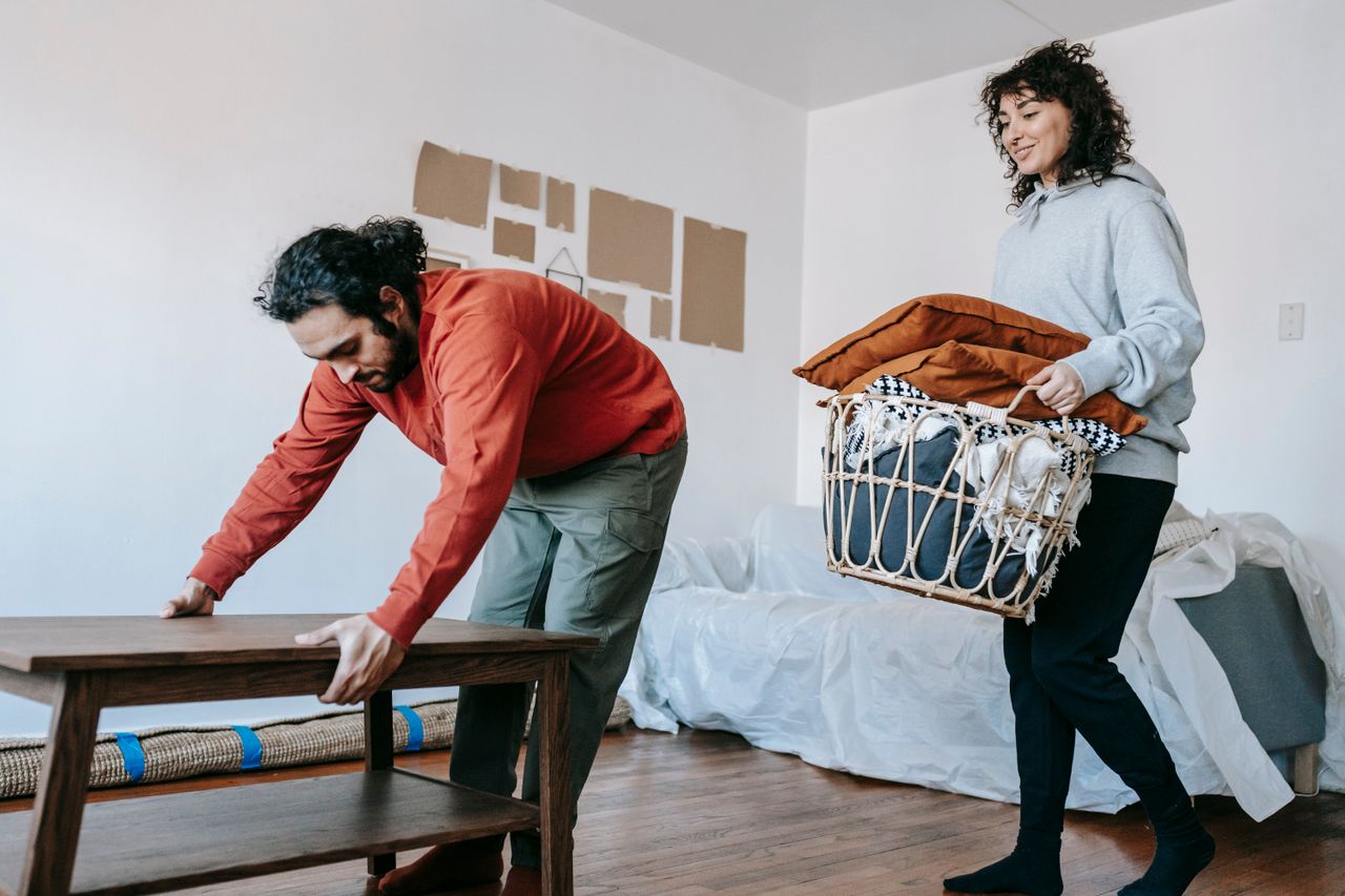 why-choose-us A couple organizing furniture and packing in a modern apartment for relocation.
